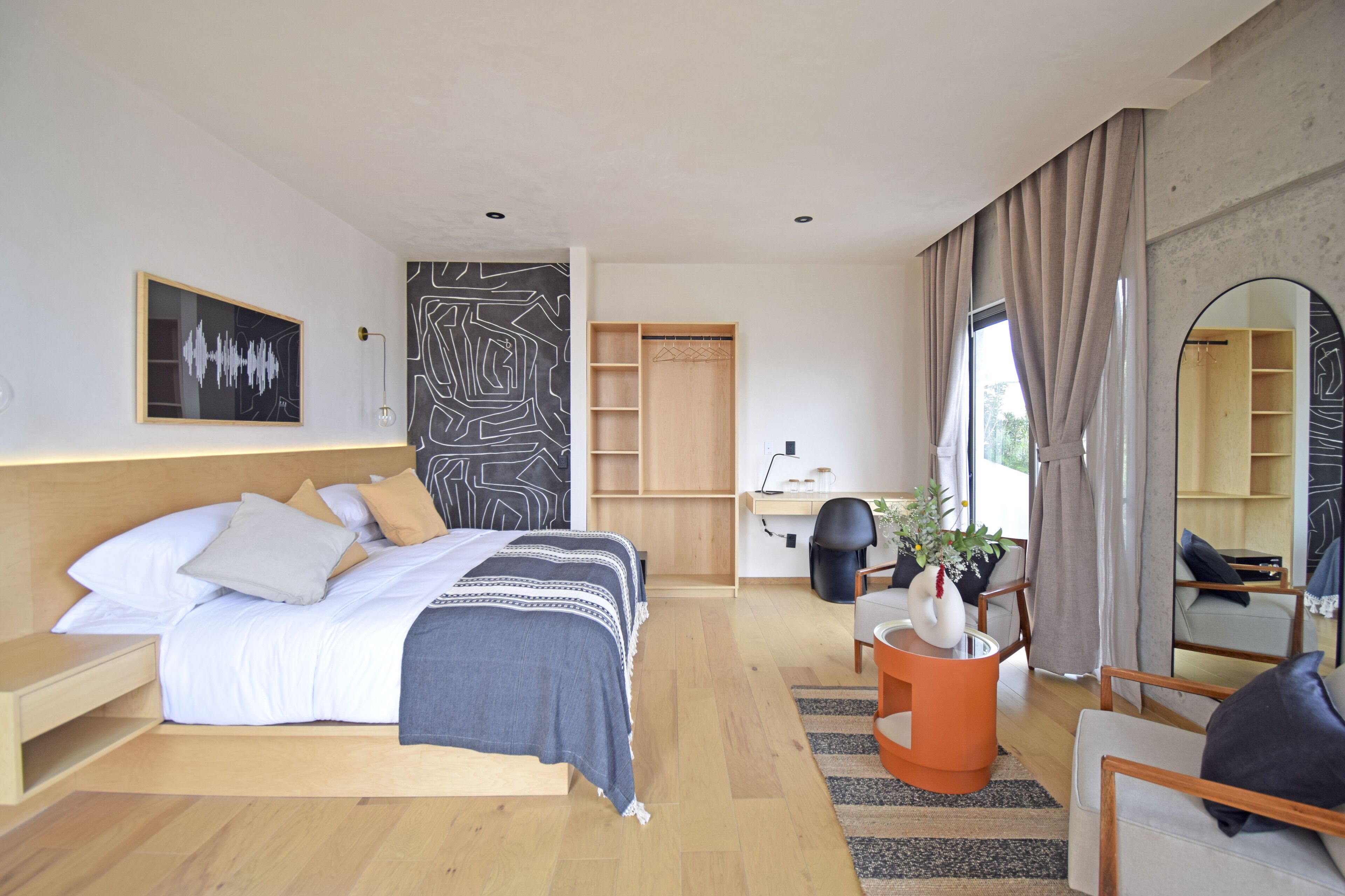 Een moderne hotelkamer met een groot bed, een bureau, een stoel en een bank.