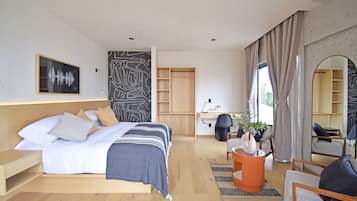 Une chambre d’hôtel moderne équipée d’un grand lit, d’un bureau, d’une chaise et d’un canapé.