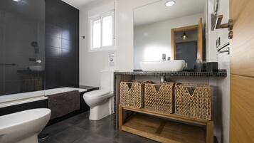Een bad/douchecombinatie, een haardroger, een bidet, handdoeken
