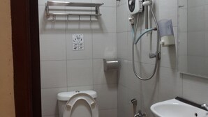 Un baño pequeño y limpio, con inodoro, lavamanos y ducha.