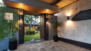 A modern villa entrance with a wooden ceiling, a sign reading "Villa Wolfe," and a fish mural on the wall. - Villa Wolfe by Villa Finder (Seminyak)