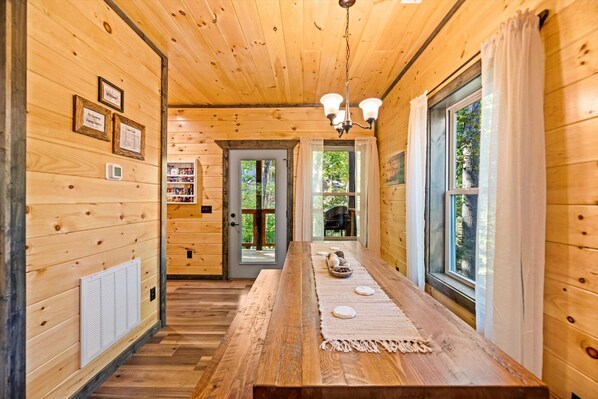 Guests can walk down this cozy hallway to a long wooden table, featuring a woven placemat and decorative stones.