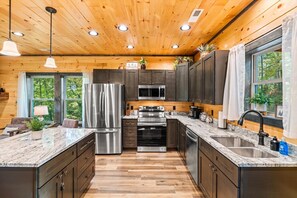 Enjoy cooking in this well-equipped kitchen with a central island, refrigerator, microwave, and oven.