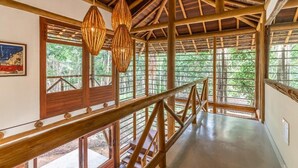 Un interior de madera con techo alto, ventanas grandes y barandilla de madera.