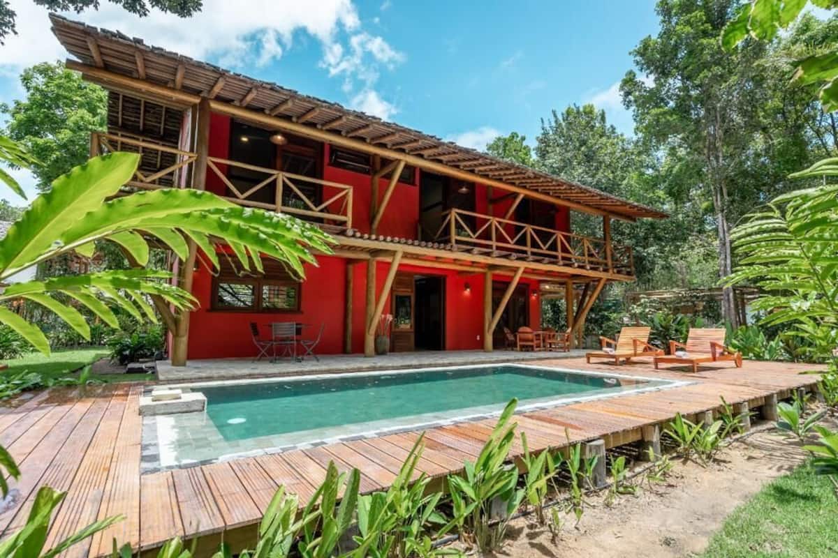 Un edificio de dos plantas con un deck de madera y una piscina.