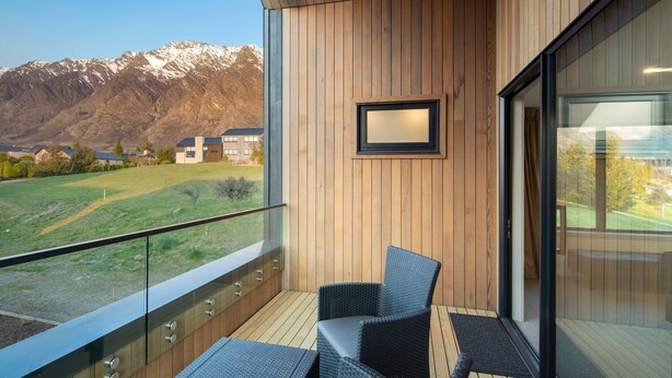 A balcony with a view of mountains, wooden paneling, and a framed picture. - Beautiful 3 bedroom home | Hot Tub | Stunning View (Jacks Point)