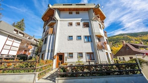 Un edificio a più piani con balconi, una scala in legno e vista sul paesaggio circostante.