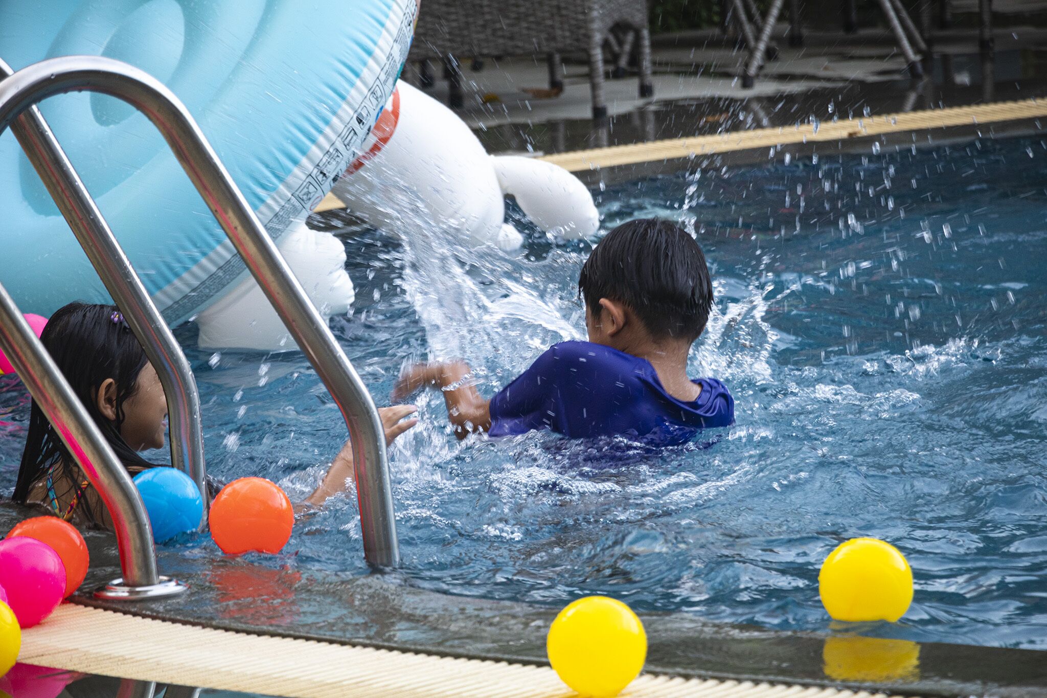 Una piscina con giochi gonfiabili e uno scalino.