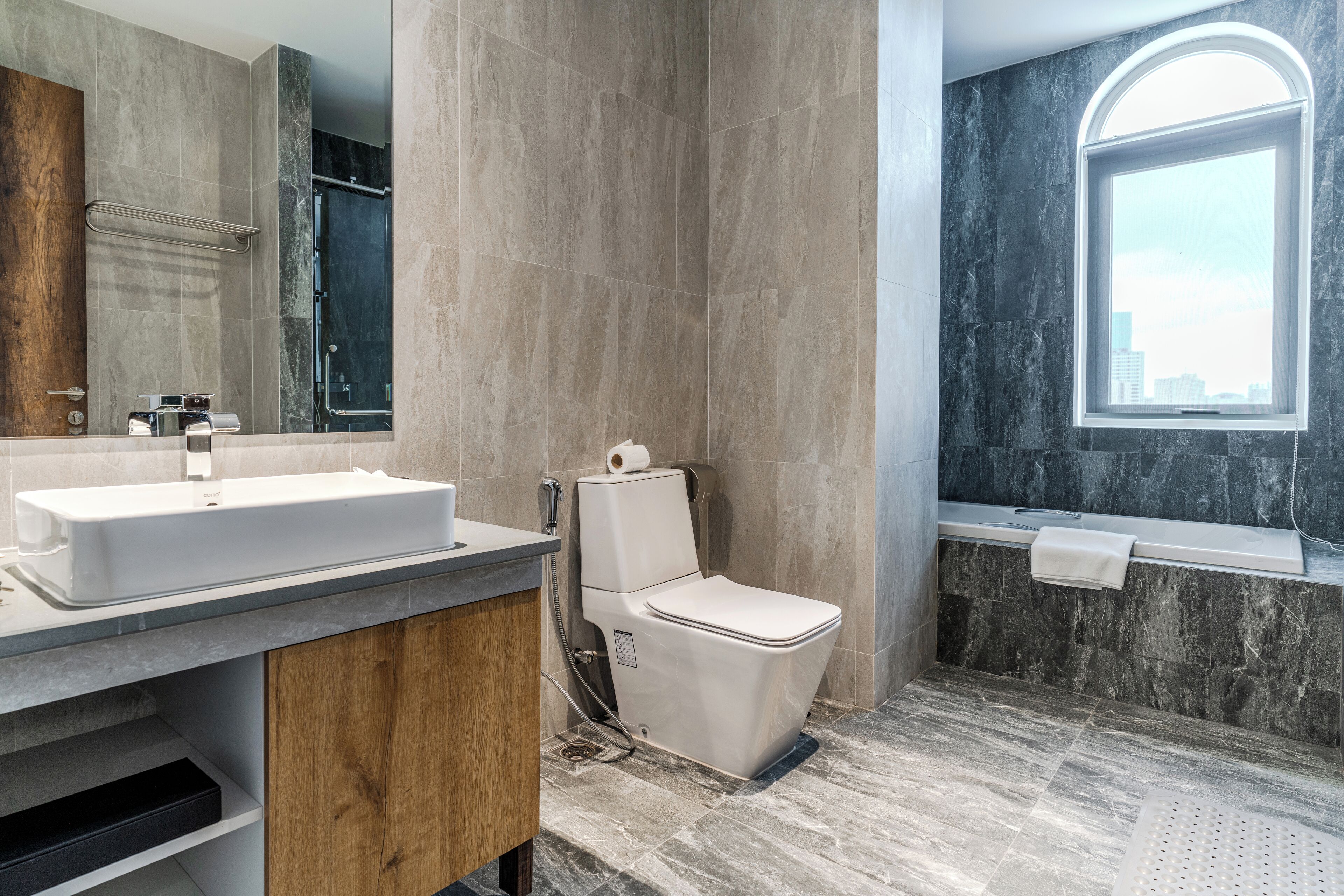 Une salle de bain moderne avec un lavabo en marbre, des toilettes et une baignoire.