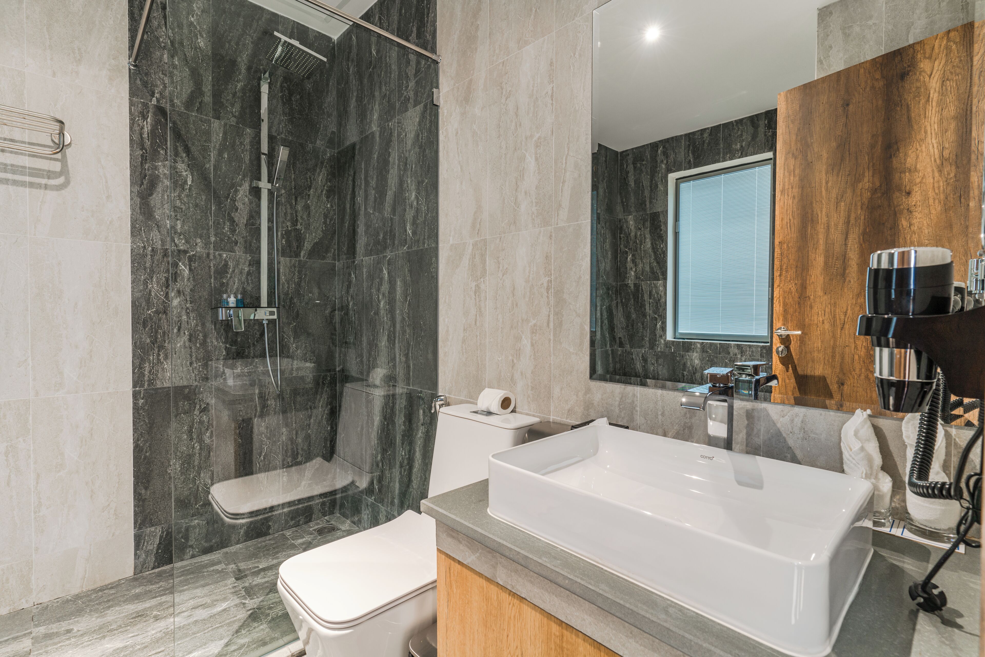 Ein modernes Badezimmer mit Badewanne, Toilette und Dusche.