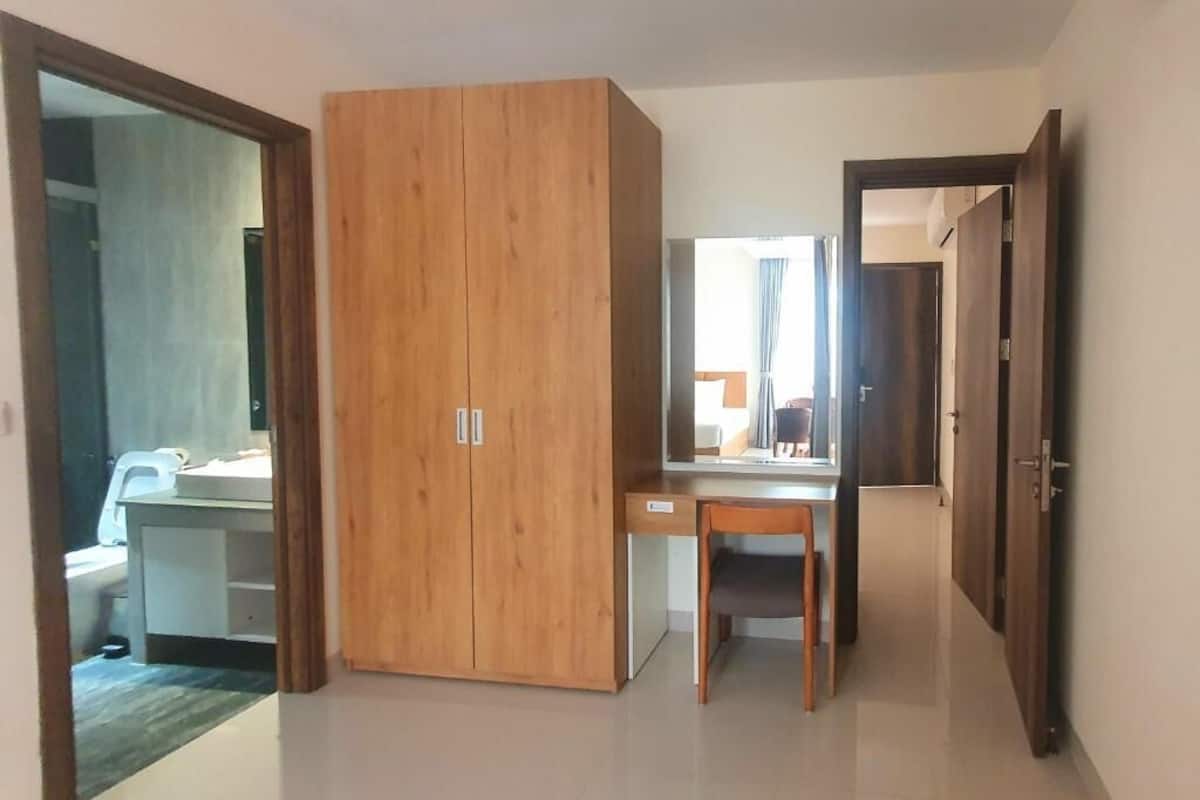 Een kamer met een houten garderobe, een bureau en een stoel.