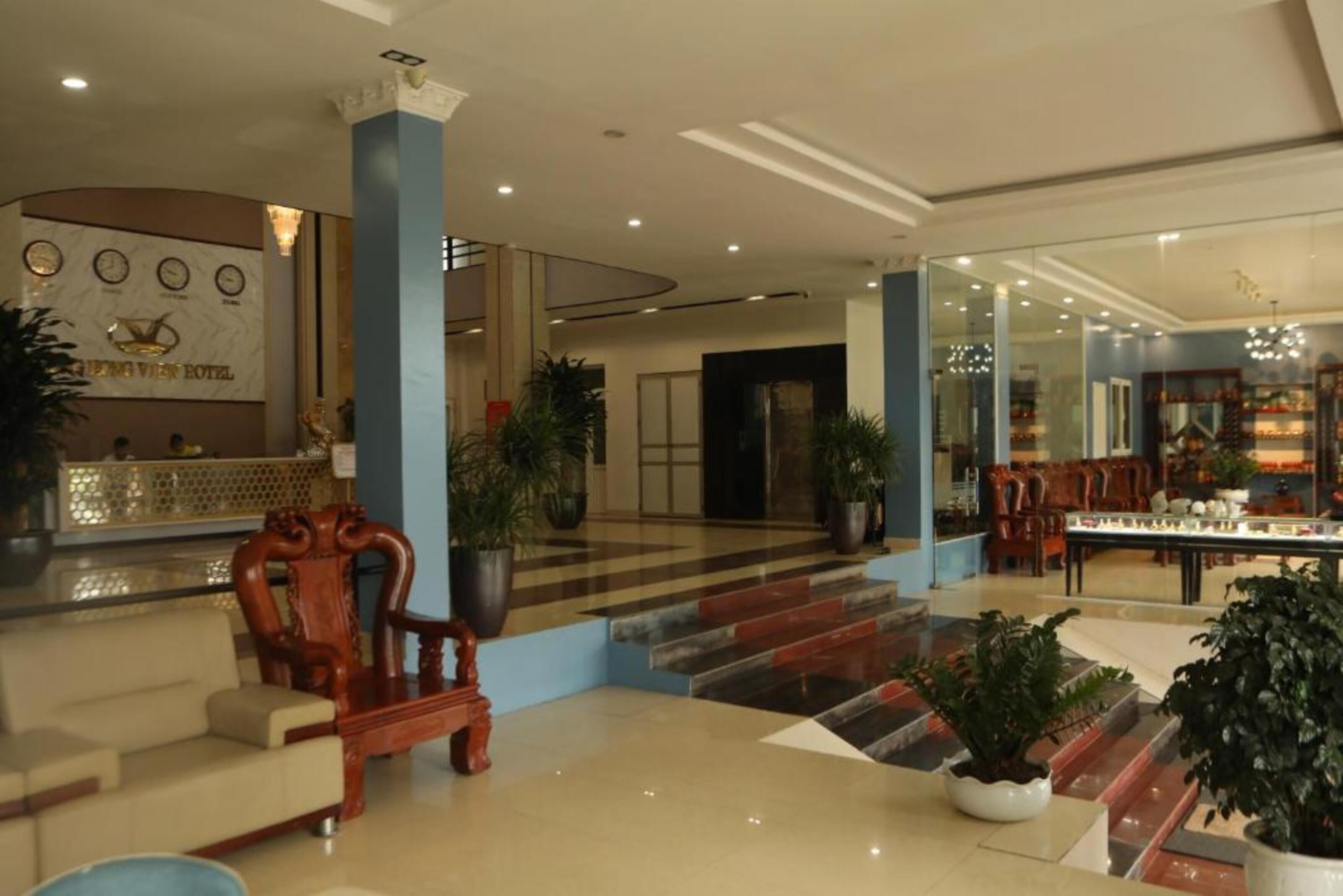 A hotel lobby with a reception desk, seating area, and a dining section.