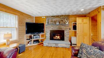 Télévision, cheminée, lecteur de DVD, baby-foot