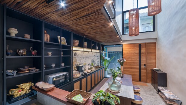 A modern kitchen with wooden shelves, a central island, and a view of the outside.