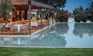 An outdoor pool area with tables and chairs, surrounded by greenery and a clear sky. - VILLA MIRTO IS PART OF THE MOLAS RESORT (Pula)