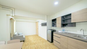 Een moderne keuken met houten kastjes, een inbouwspoelbak en een compacte koelkast.