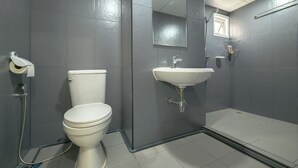 Een moderne badkamer met toilet, wastafel en douche.