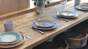 Ein Holztisch mit Tellern, Besteck und einem Glas.