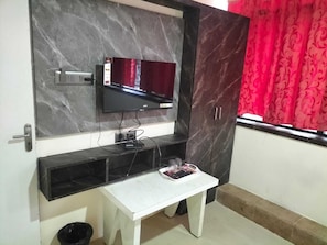 Cozy living space with a flat-screen TV, dining table, and comfortable chair.