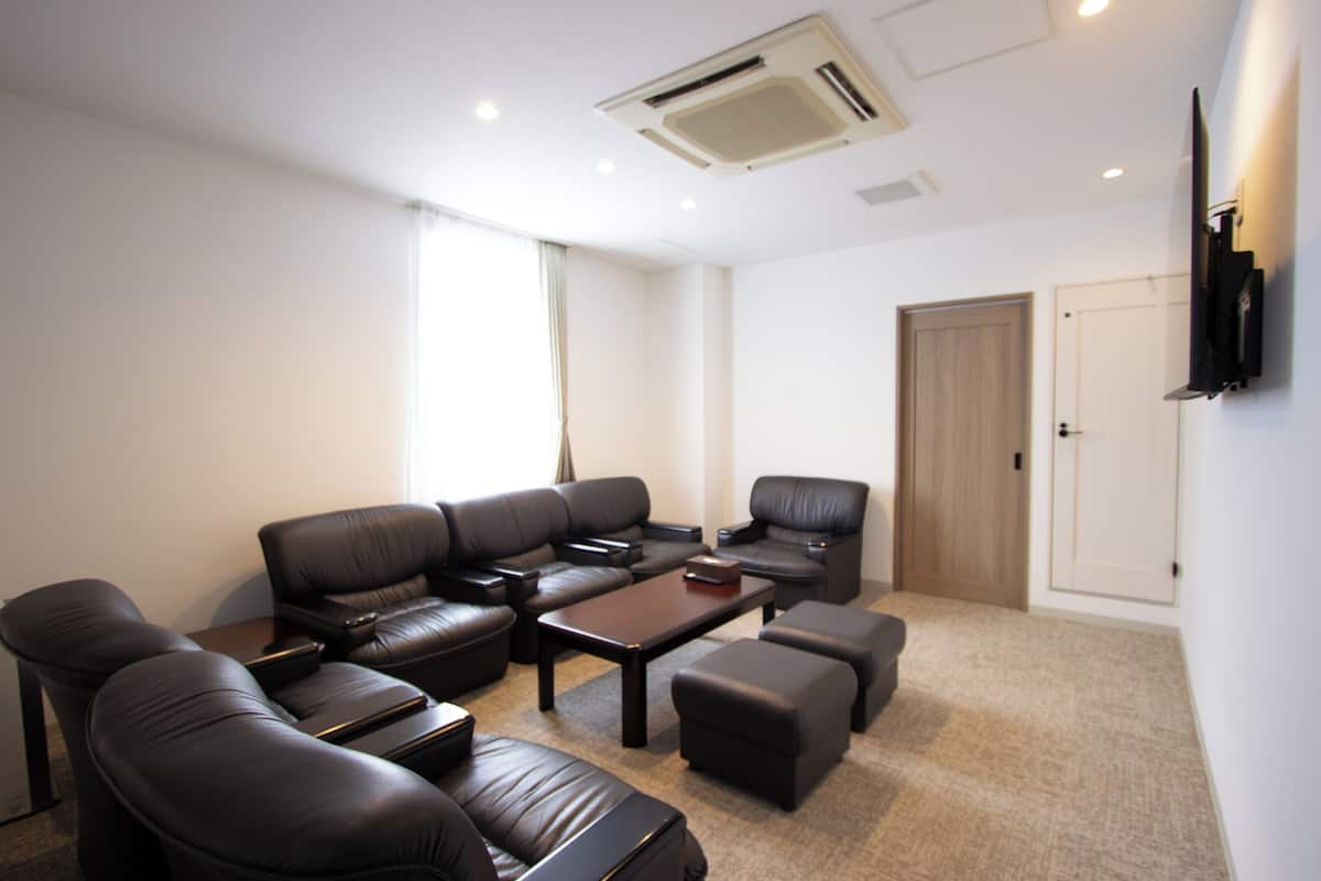 A modern living room with a sectional sofa, a coffee table, and a TV mounted on the wall.