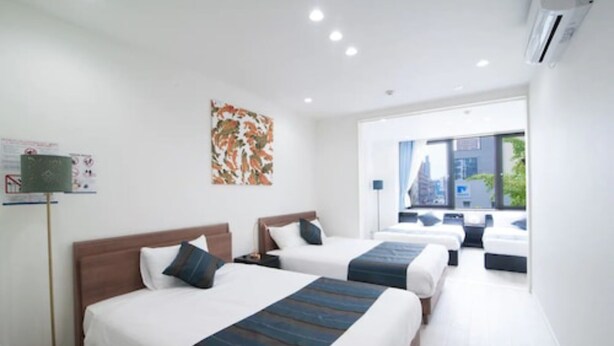 Een hotelkamer met twee bedden, een groot raam en uitzicht op de stad.