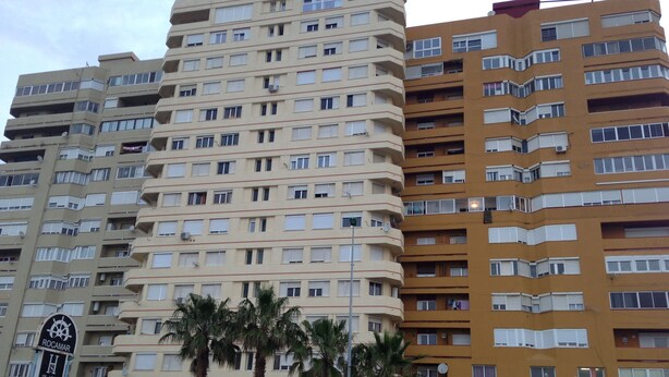 A multi-story hotel with balconies, palm trees in front, and a sign for 'Ocean Destiny Tavern'. - Loft con Espectaculares Vistas al Mar, Gibraltar, Marruecos y Bahía de Algeciras (La Línea de la Concepción)