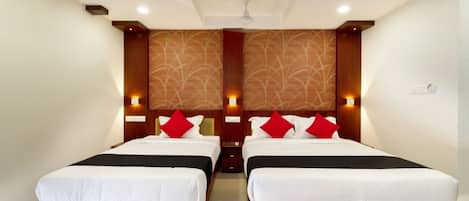 Une chambre d’hôtel avec deux lits, une tête de lit en bois et un mur décoré d’un motif.
