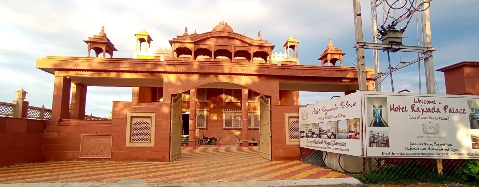 De ingang van Hotel Rajwada Palace, met een bord waarop de naam en faciliteiten staan.