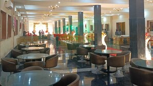 A spacious hotel lobby with multiple seating areas, a chandelier, and a patterned ceiling. - Hotel Rajwada Palace (Nivari)