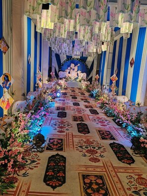 Un pasillo decorado con arreglos florales y un altar central.