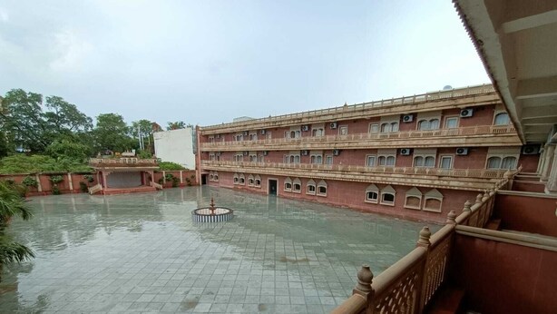 A large building with multiple balconies and a central courtyard with a fountain. - Hotel Rajwada Palace (Nivari)