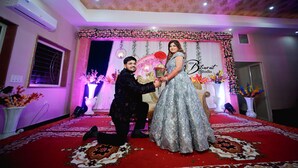 A decorated indoor space with a red carpet, floral arrangements, and a sign reading "New Bhurat Studio." - Hotel Rajwada Palace (Nivari)