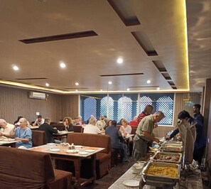 Un restaurante con varias mesas y una barra de buffet.