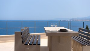 Une terrasse avec une table, deux bancs et deux verres à vin.
