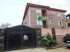 A two-story building with a gated entrance, a balcony, and multiple windows. - Hardrock Hotel and Suites Ltd (Lagos)