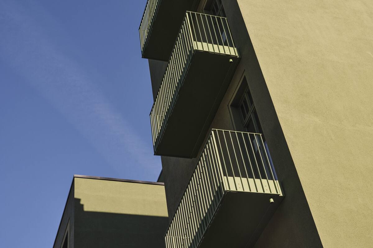 A building with a modern architectural style, featuring a series of balconies with metal railings.
