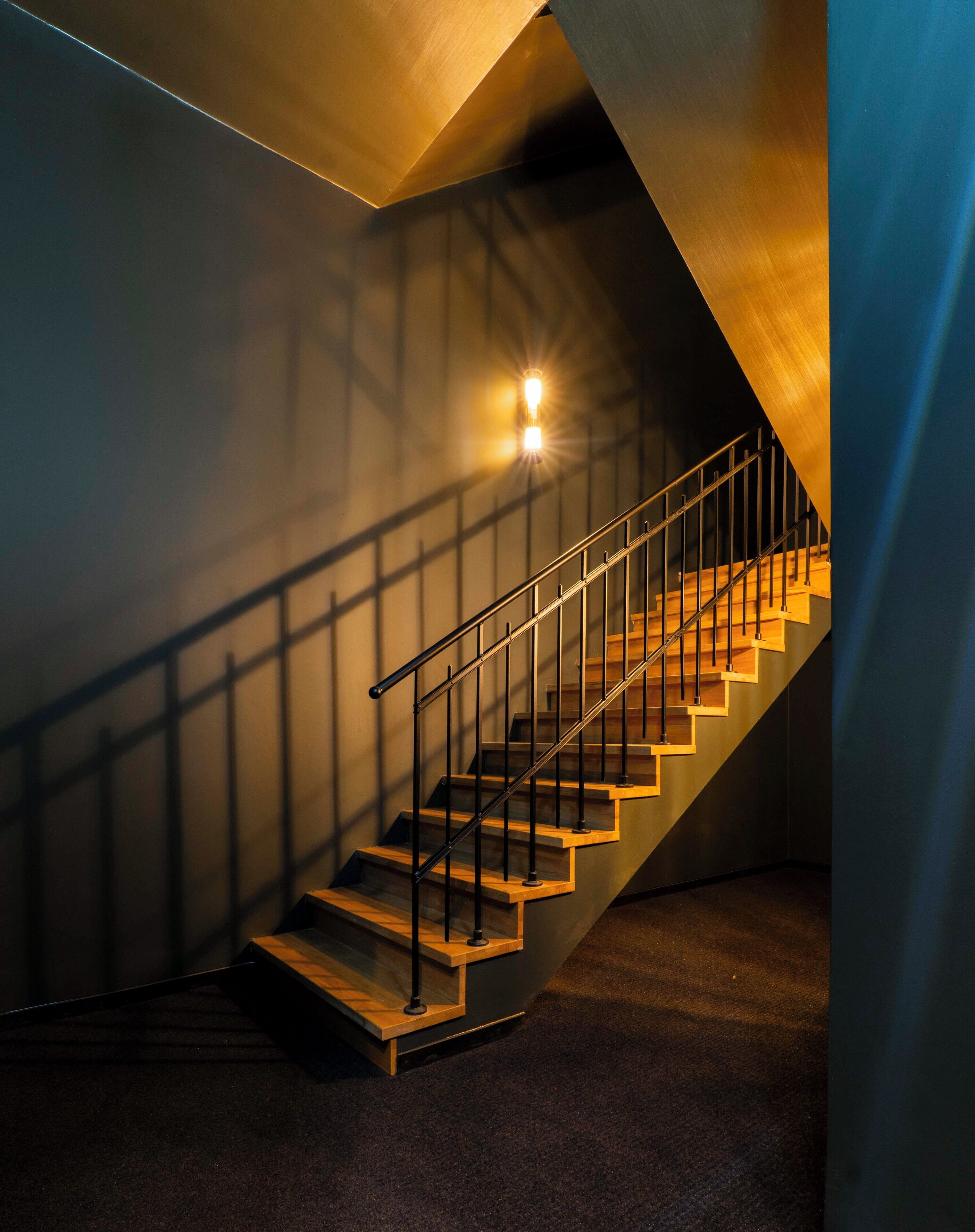 A staircase with wooden steps and metal railings, leading to a higher floor.