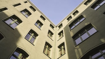 A corner view of a building with multiple windows and a textured facade.