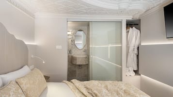 Une chambre à coucher moderne avec un grand lit, une coiffeuse avec un miroir et un peignoir accroché au mur.