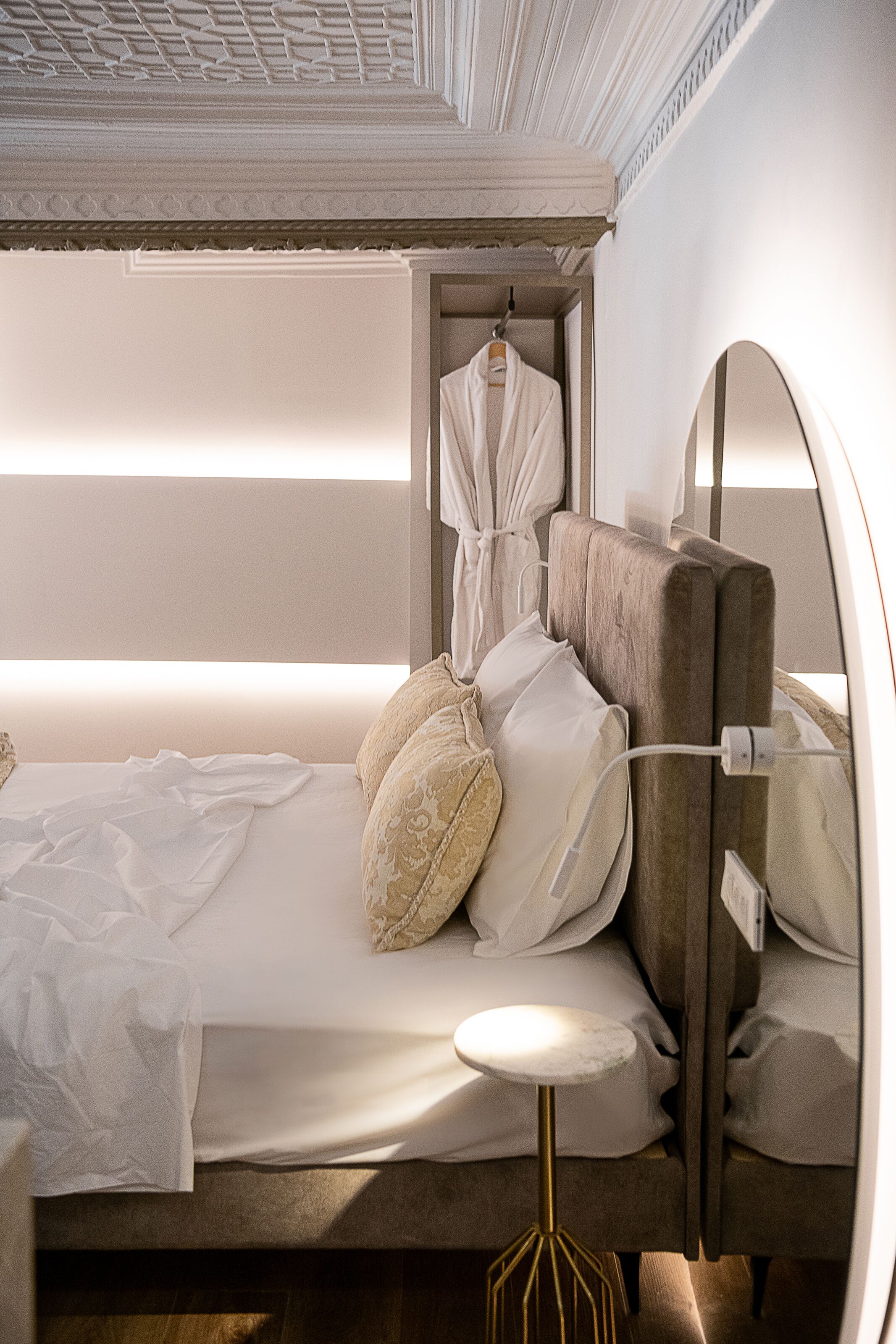 Une chambre à coucher moderne avec un lit superposé, une table de chevet et un porte-manteau mural.