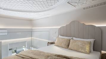 Un dormitorio con cama, mesita de noche, lámpara y un separador de vidrio.