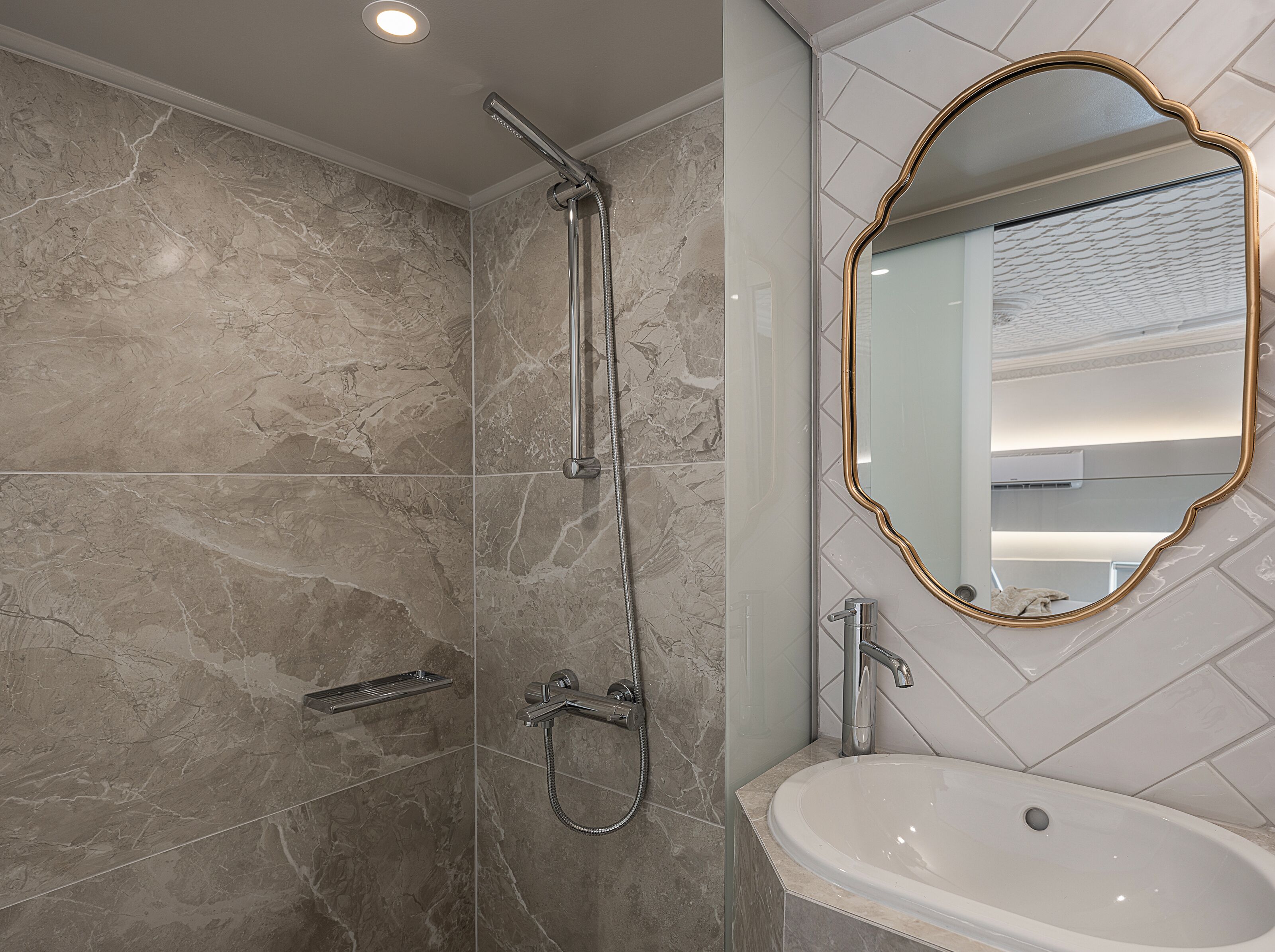 A bathroom with a shower, a sink, and a mirror.