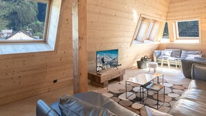 Ein gemütlicher Holzraum mit einer Couch, einem Couchtisch und einem Gemälde.