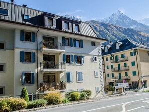 Un hôtel à plusieurs étages doté de balcons, offrant une vue sur la montagne et disposant d’un parking.