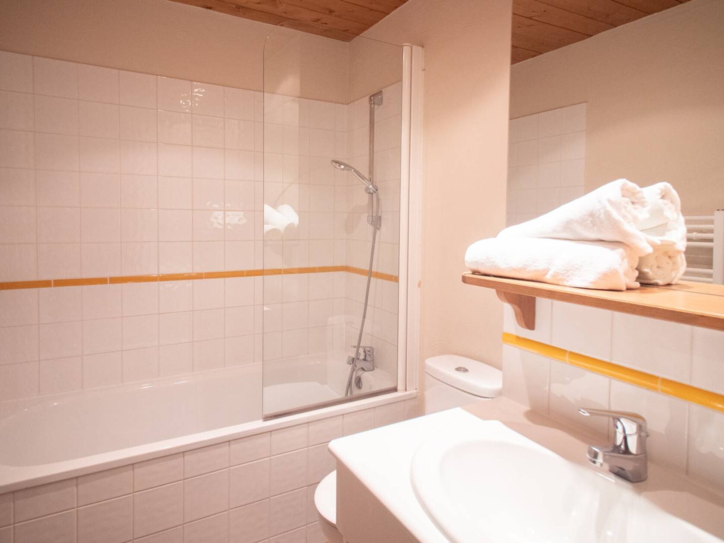 A bathroom with a shower, toilet, and sink.