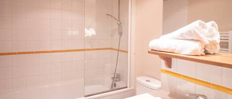 A bathroom with a shower, toilet, and sink.