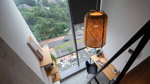 A modern interior with a large window, a hanging lamp, and a staircase. - Cove Hillcrest (Curug)