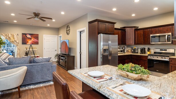 A modern kitchen with dark wood cabinets, stainless steel appliances, and a granite countertop. - Luxurious AC Home Near Heart of Downtown, NAU, Snowbowl, Historic Route 66 (Flagstaff)