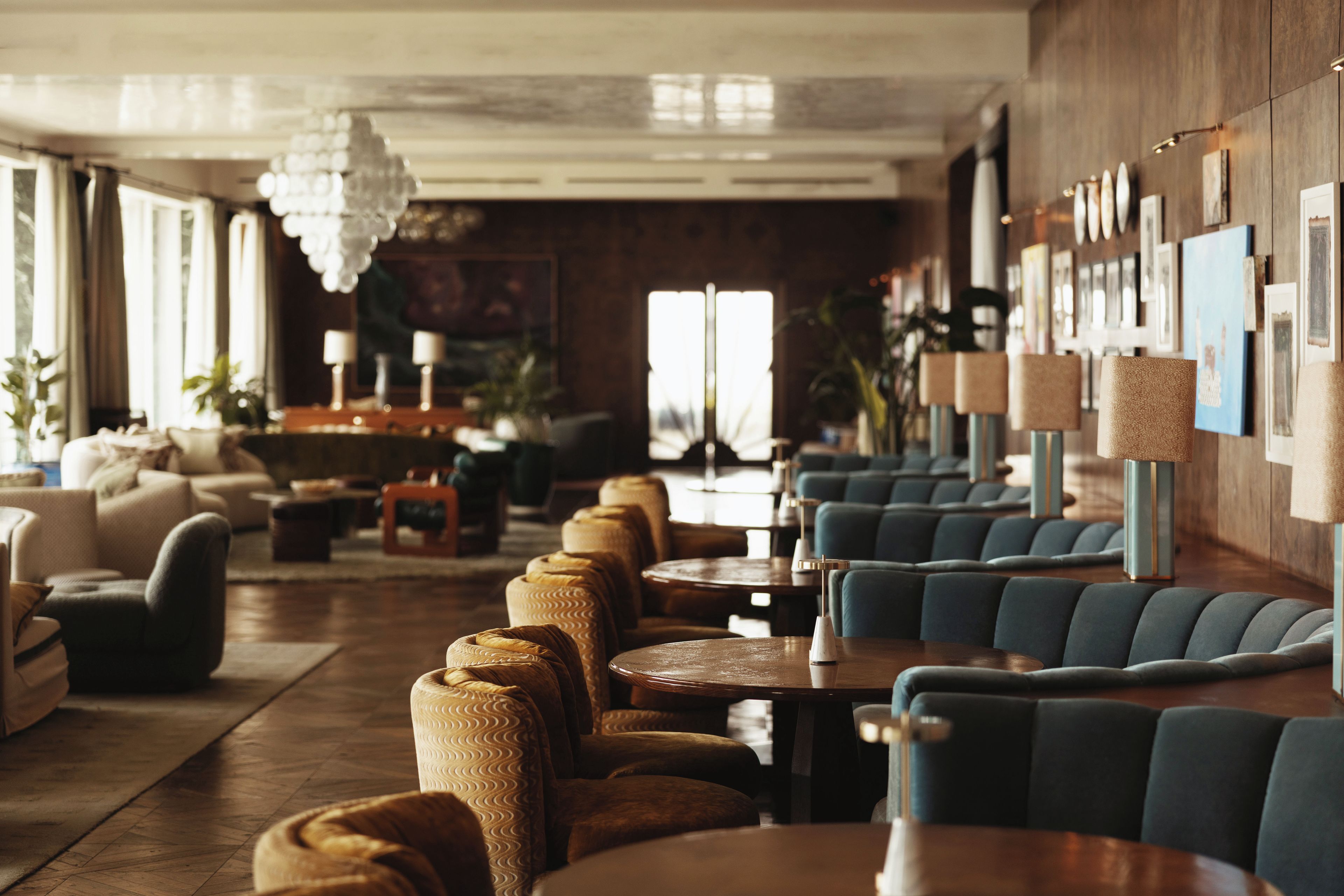 Un hall d’hôtel doté d’espaces aménagés avec des sièges, des tables et des œuvres d’art accrochées aux murs.