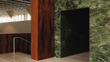 Een modern interieur met een houten kolom, een marmeren wand en een hanglamp.